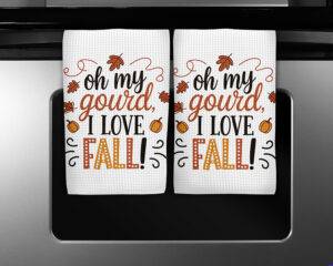 Funny fall kitchen towel design with the phrase "Oh My Gourd, I Love Fall" featuring pumpkins and autumn leaves.