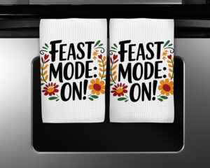 Funny sublimation design on white kitchen towels that says "Feast Mode: ON!" with autumn flowers and fall colors