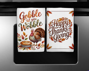 Thanksgiving kitchen towel sublimation designs featuring Gobble ’Til You Wobble turkey and Happy Thanksgiving leaf wreath illustrations.