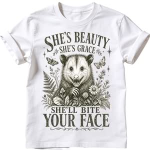 She's beauty she's grace she'll bite your face sublimation PNG on white t-shirt with grinning opossum paw raised wildflowers ferns butterflies dark olive-sepia vintage engraving style funny wildlife humour